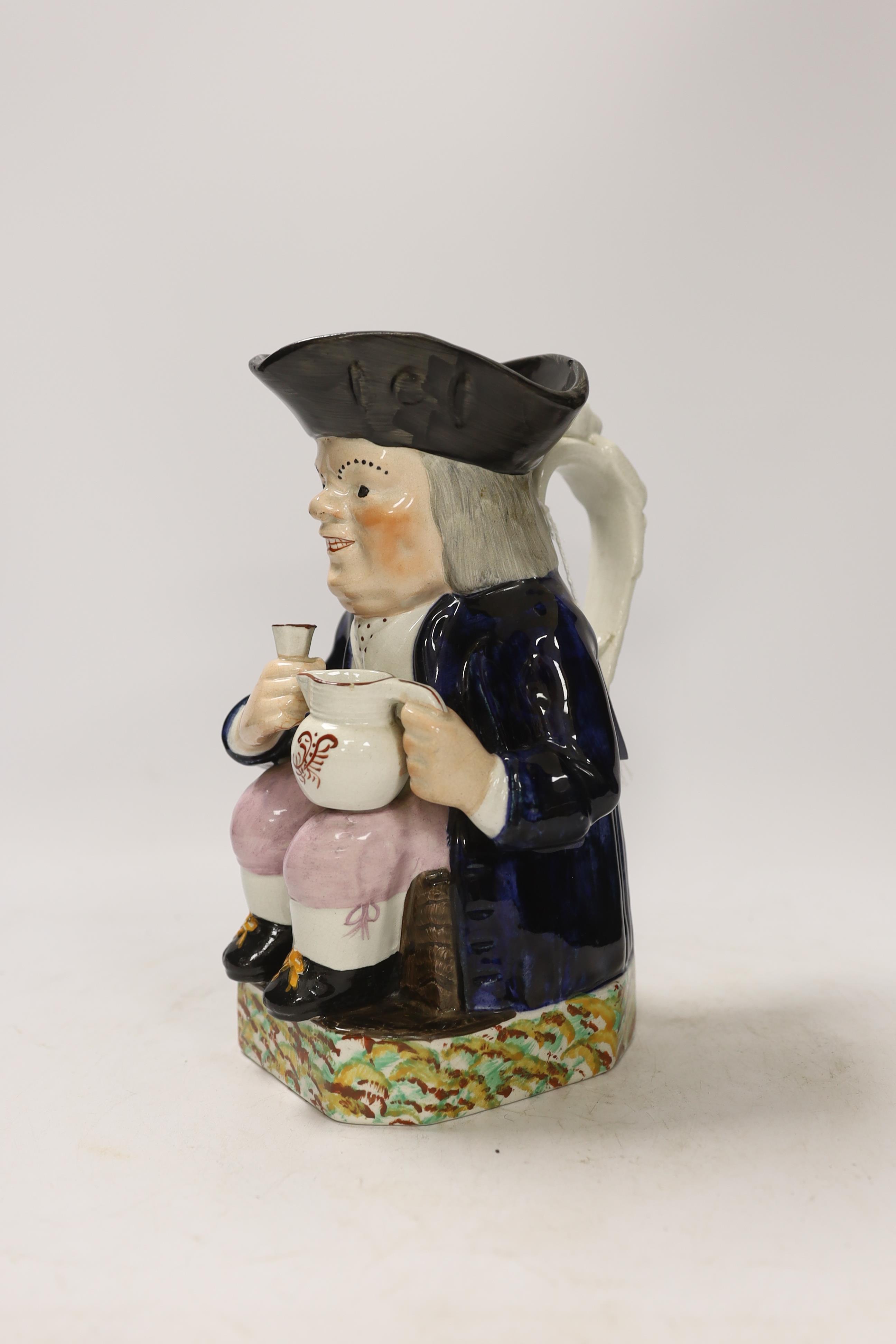 A Mexborough Toby jug, modelled holding a jug and a beaker, caryatid figural handle, black hat and sponge decorated base, 25cm high. Condition - fair